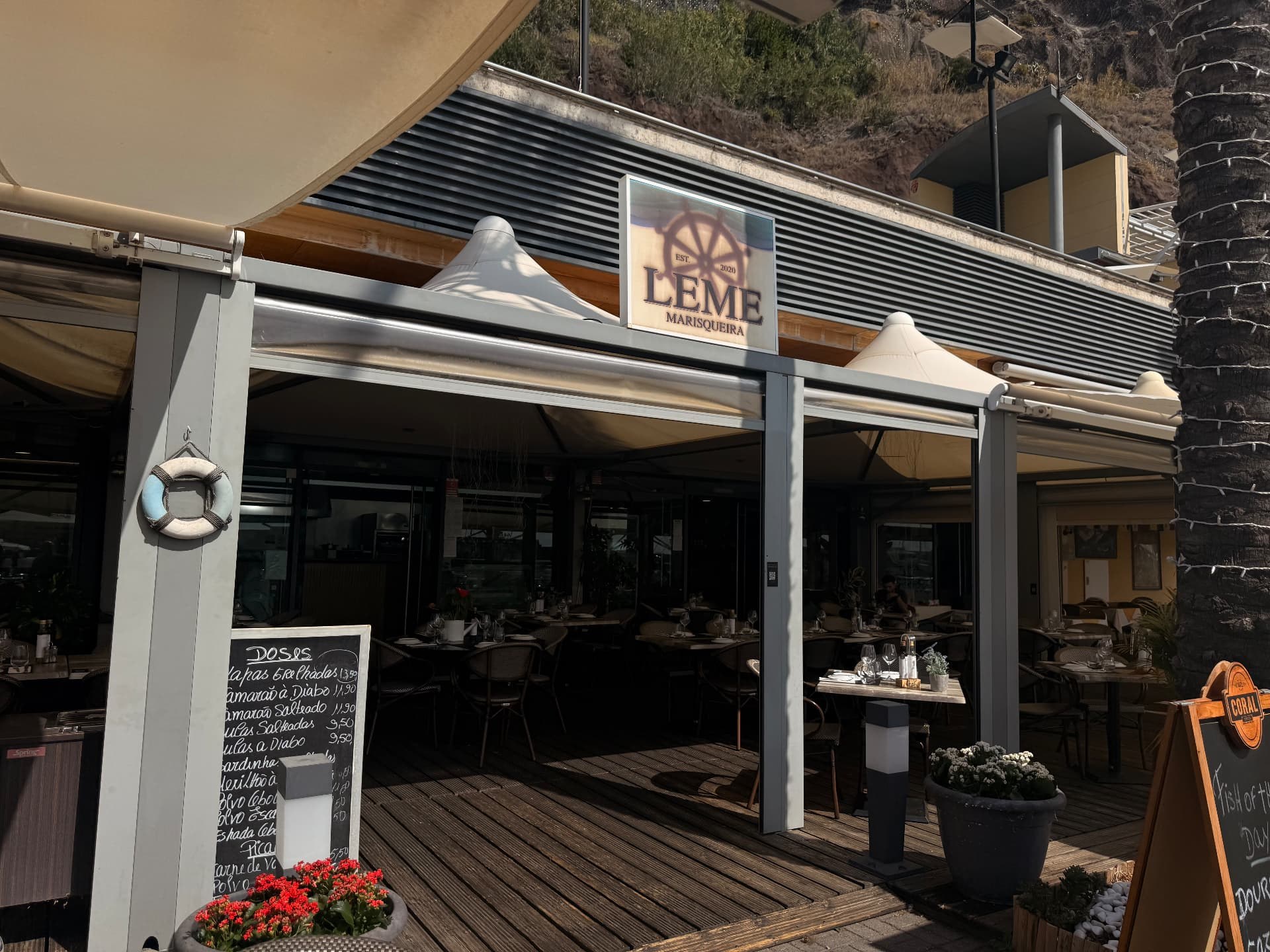 Named frontage and covered wooden terrace of Leme Marisqueira at Calheta marina.