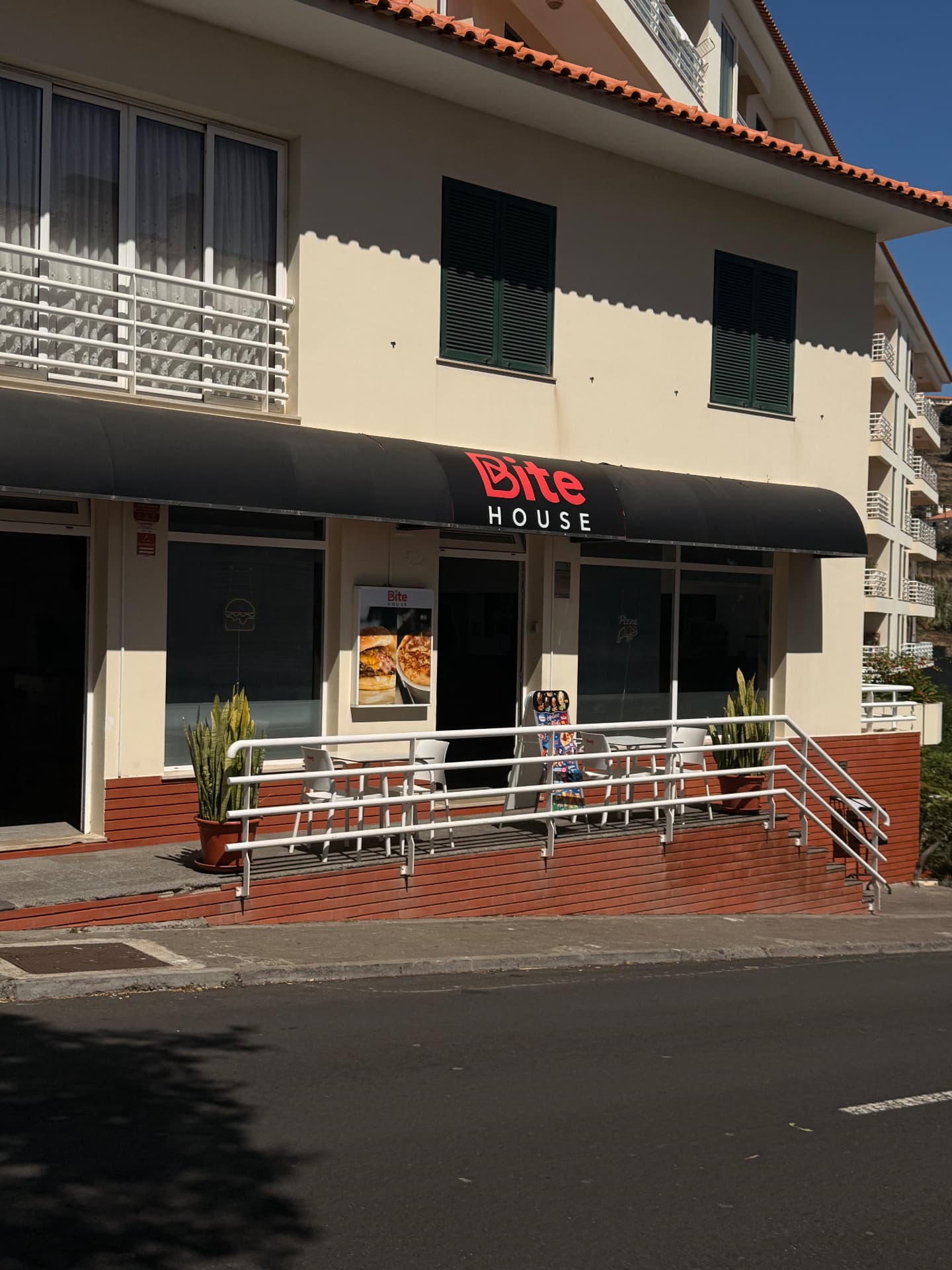 Esplanada de mesas brancas do Bite House, Caniço