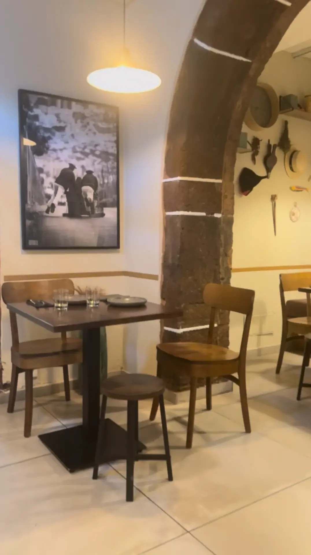 Wooden dining tables beneath a stone arch inside Jaket restaurant in Funchal